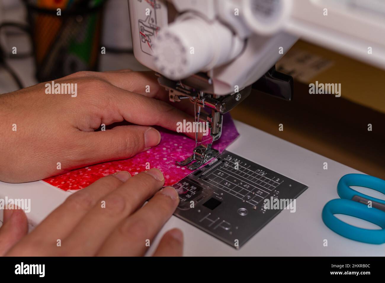 Nicht erkennbare Näherin, die mit der Nähmaschine arbeitet. Stockfoto