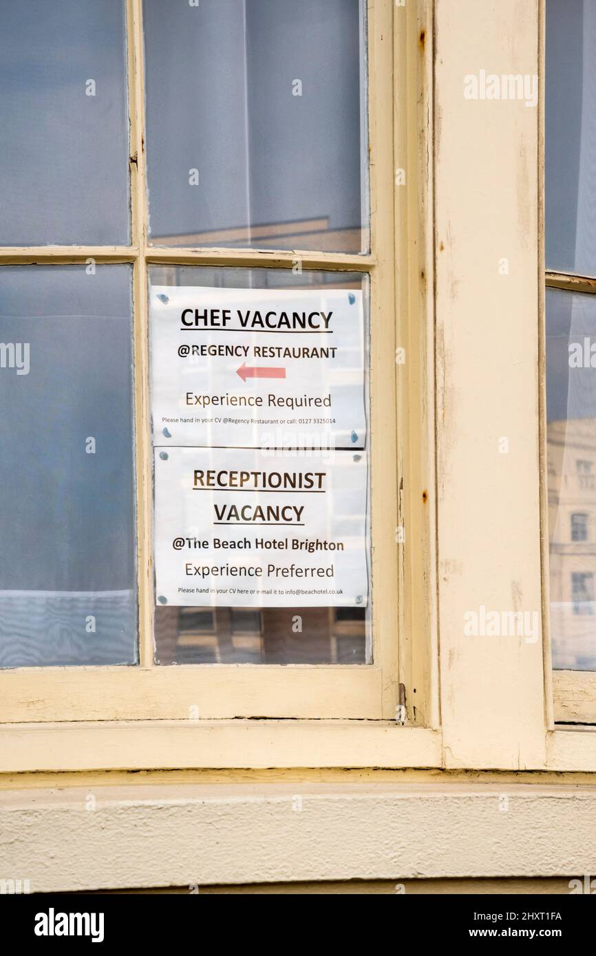 Stellenanzeigen in einem Brighton-Fenster für einen Koch und eine Empfangsdame in der Hotellerie. Stockfoto