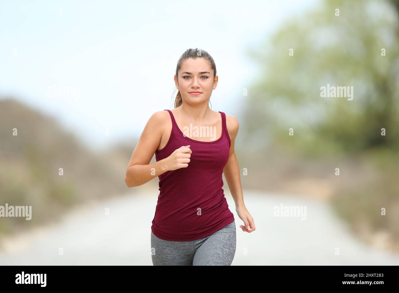 Vorderansicht Porträt eines Läufers, der im Berg zur Kamera joggt Stockfoto