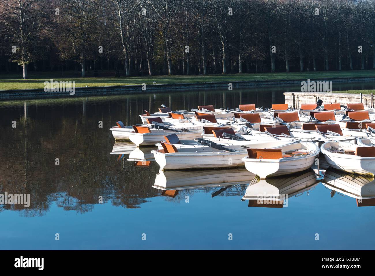 Spiegelungen von Holzbooten auf einem See im Park in Versalles Stockfoto