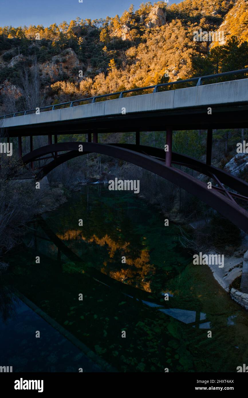 Vertikale Aufnahme einer Brücke und ihrer Reflexion im Fluss Tejo im Naturpark Alto Tajo, Spanien Stockfoto