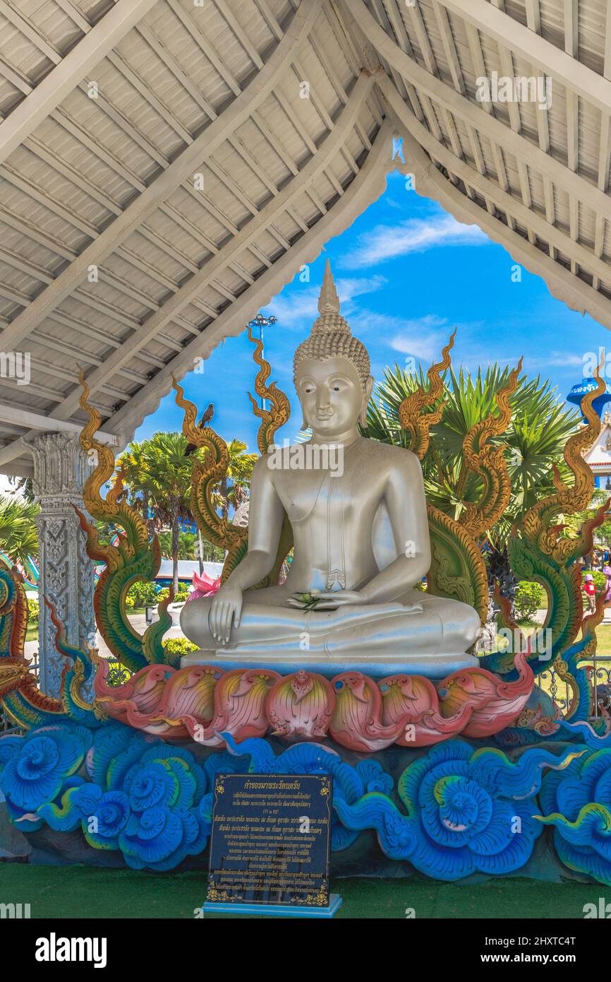Vertikales Foto einer silbernen Buddha-Statue und chinesischen goldenen Drachen in einem Tempel in Thailand Stockfoto