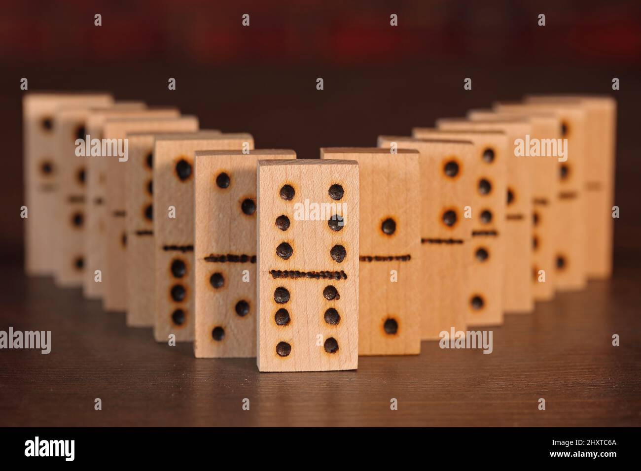 Foto von hölzernen Dominosteinen auf einem Tisch aufgereiht Stockfoto