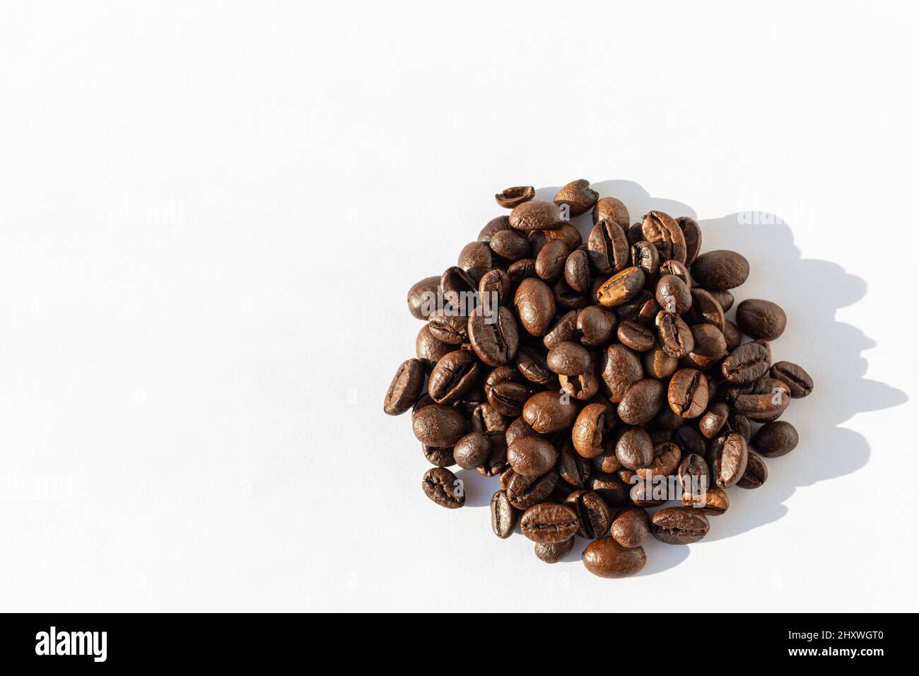 Haufen von Robusta, Arabica-Kaffeebohnen isoliert auf weißem Hintergrund, Kopierbereich, Draufsicht. Kaffeebohnen für Latte, Cappuccino, Mokka, Americano-Kaffee, Stockfoto