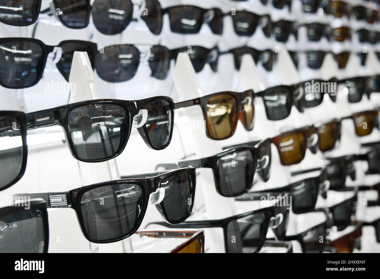Viele Sonnenbrillen auf der Theke eines optischen Ladens. Sortiment an Sonnenbrillen. Stockfoto