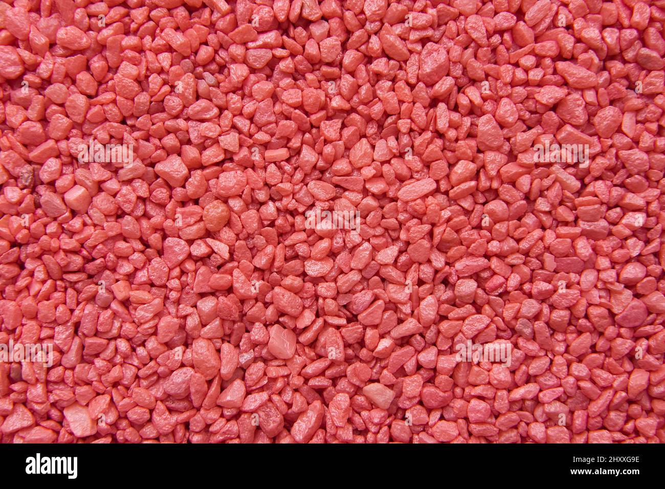 Textur aus roten dekorativen kleinen Steinen. Abstrakter Hintergrund. Stockfoto