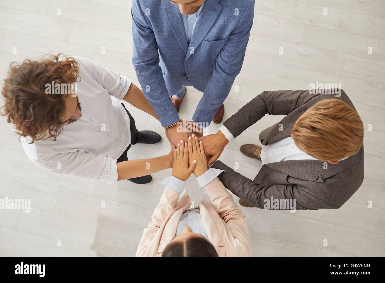 Draufsicht auf eine Gruppe von Geschäftsleuten, die zusammenstehen und sich zusammenschließen Stockfoto
