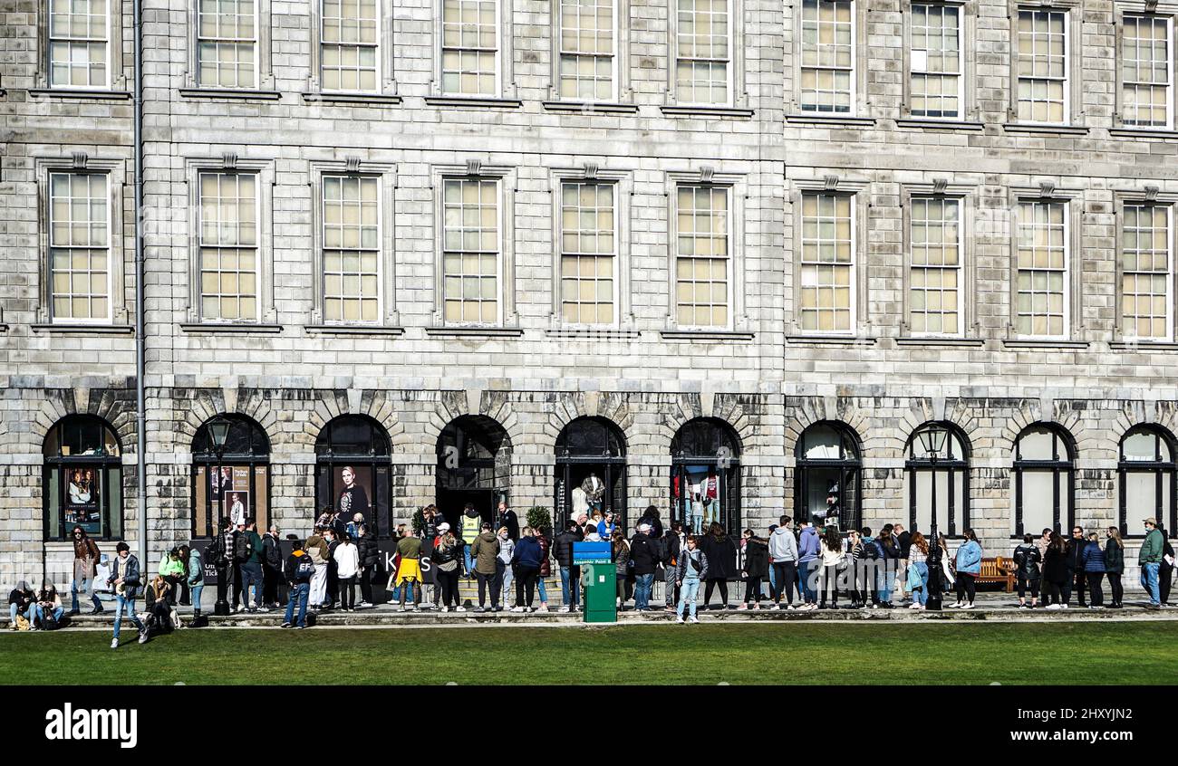 Menschenmassen, die Schlange stehen, sehen sich das Book of Kells im Trinity College, Dublin, Irland an. Stockfoto