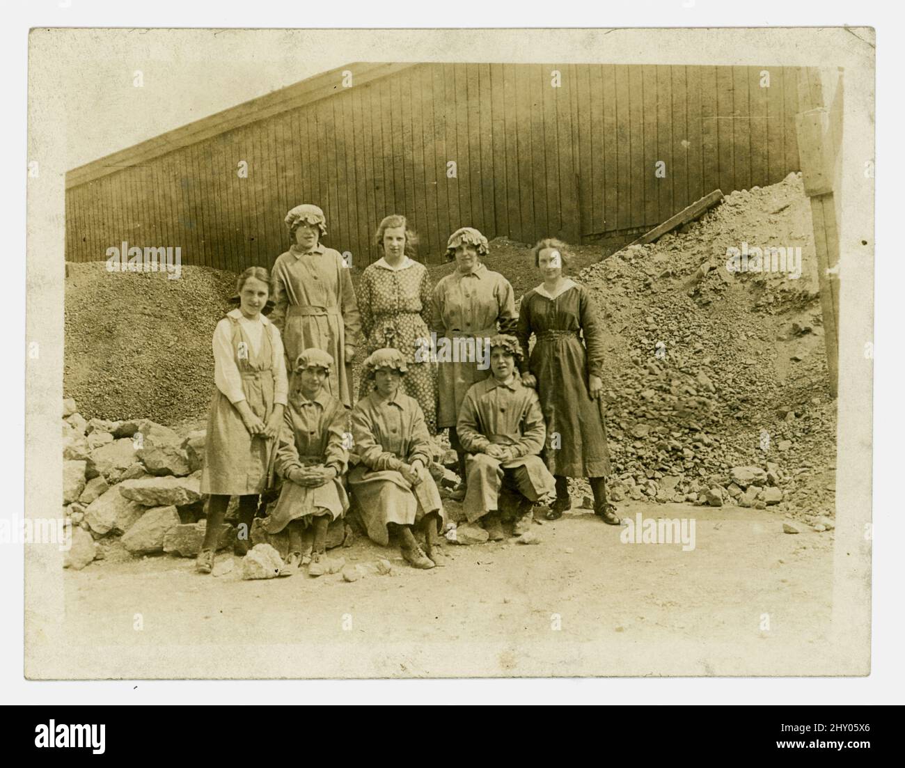 Originalfoto aus der Zeit von WW1 von einer Gruppe weiblicher Steinbrucharbeiterinnen, die die Arbeit von Männern verrichten, die im Krieg gekämpft haben. Die Mädchen tragen Uniform und sitzen zwischen Steinbrüchen. Runcorn, Khishire, Großbritannien, um 1916. Stockfoto