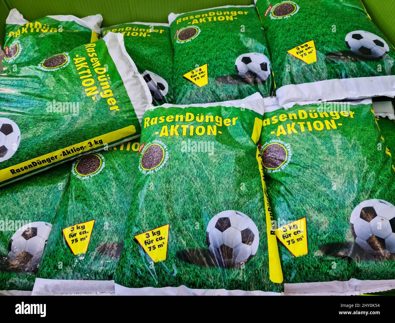 Säcke Rasendünger mit Fußballwerbung darauf im Verkaufsbereich eines Gartencenters Stockfoto