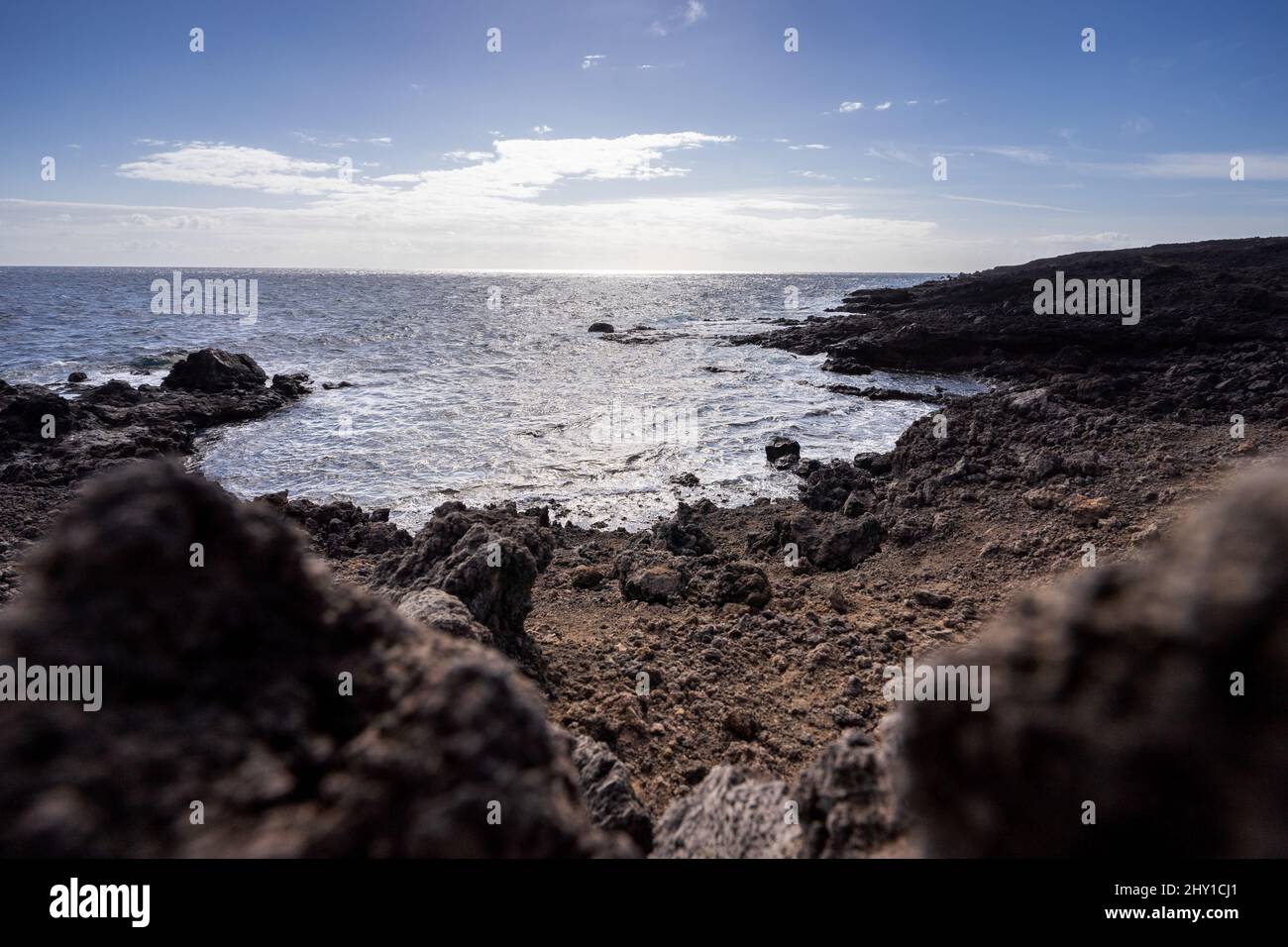 Landschaft von felsigen Ufer mit Felsbrocken der vulkanischen Insel Teneriffa, die am sonnigen Tag vom Atlantischen Ozean gewaschen wurden Stockfoto