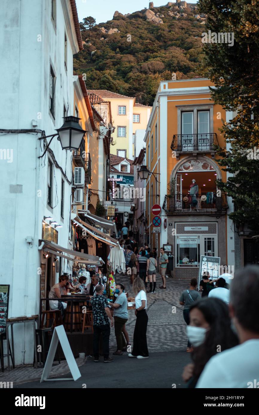 Aufnahme von Menschen, die in der Straße zwischen den alten Gebäuden der Altstadt von Sintra, Lissabon, Portugal, spazieren gehen Stockfoto