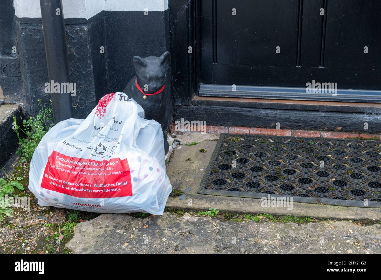 Charity-Tasche voller gespendeter Immobilien vor der Haustür, bereit zur Abholung, Großbritannien Stockfoto