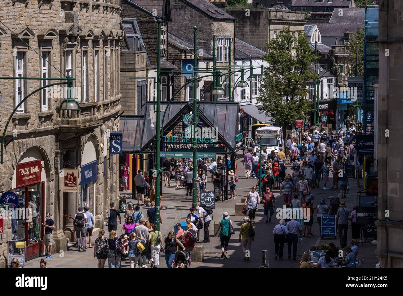 Buxton High Street ist während der Sommersaison in Buxton, England, mit Einkäufern und Touristen beschäftigt Stockfoto
