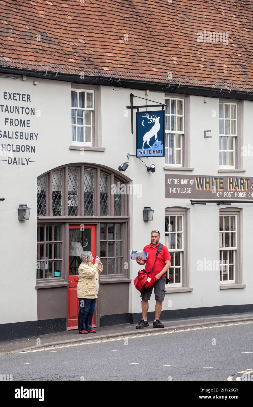 Das White Hart Inn oder Pub mit Postboten, die Post im Zentrum von Overton Village, Hampshire, England, Großbritannien, liefern Stockfoto