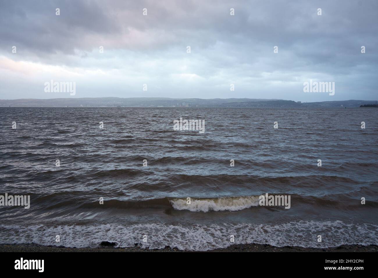Blick über den Fluss Clyde von Helensburgh aus, mit Greenock und Gourock in der Ferne über das Wasser, wenn es dunkel wird Stockfoto