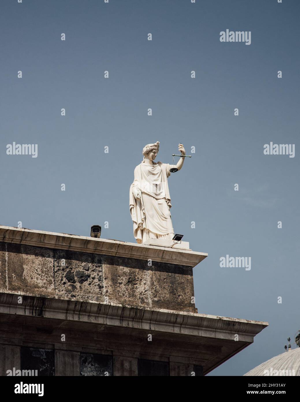 Vertikale Aufnahme einer Mythologie-gottesstatue auf einem Dach. Stockfoto