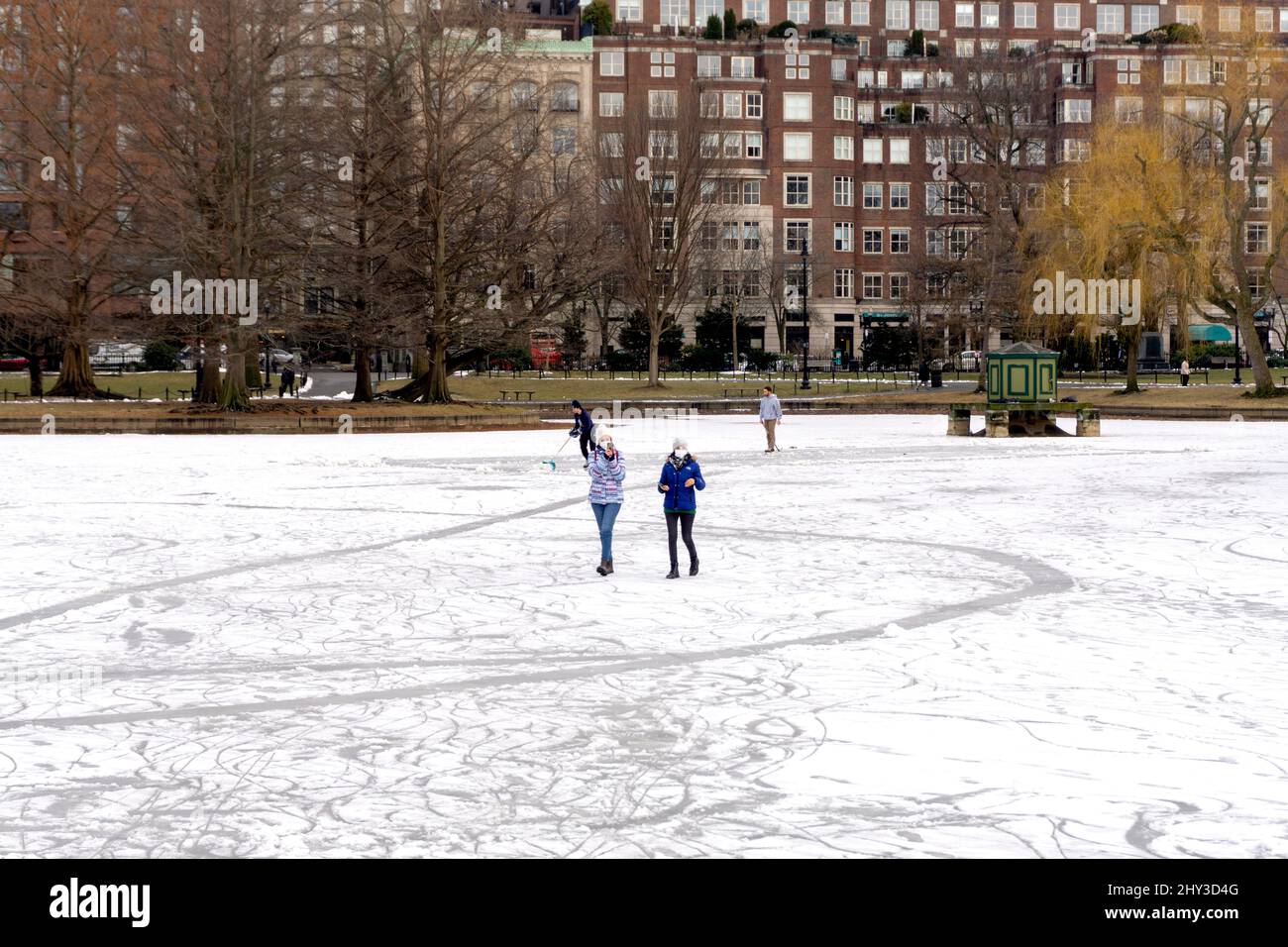Menschen, die im Winter auf dem gefrorenen Boston Public Garden Teich spazieren und skaten Stockfoto