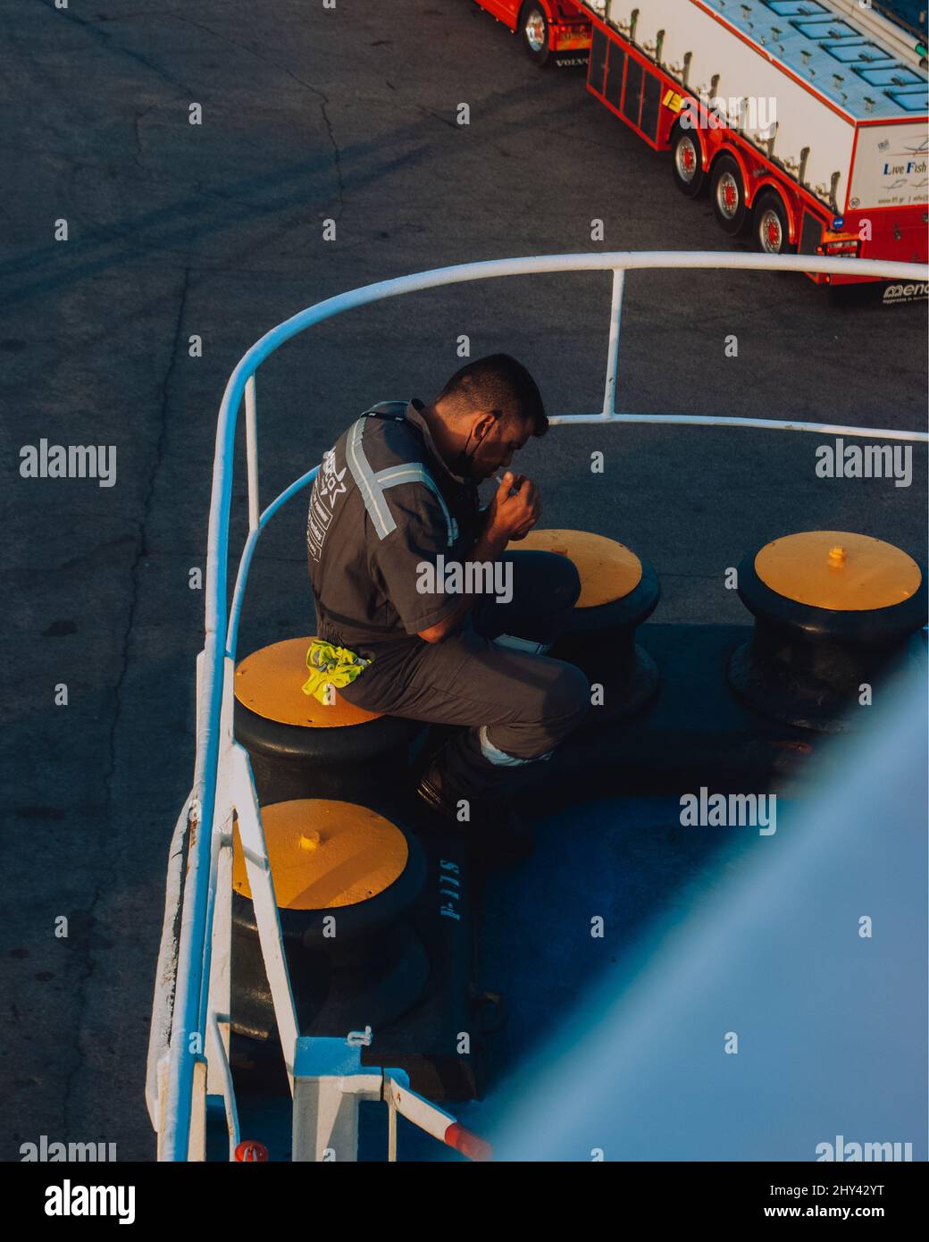 Ein Besatzungsmitglied raucht an einem sonnigen Tag im Schiff eine Zigarette Stockfoto