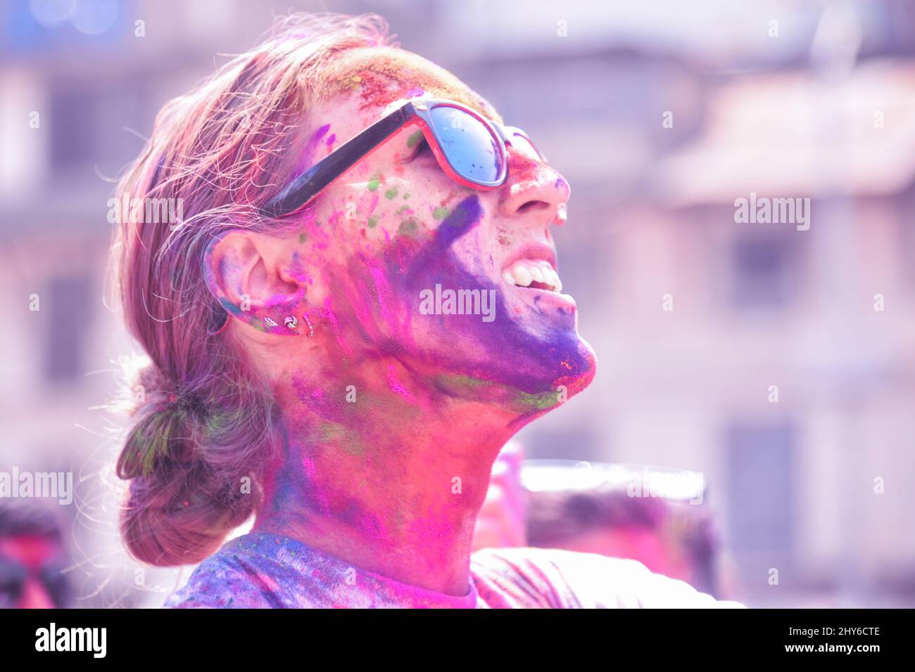 Junge Touristin mit farbenfroher Farbe genießt das Holi-Festival in Nepal Stockfoto
