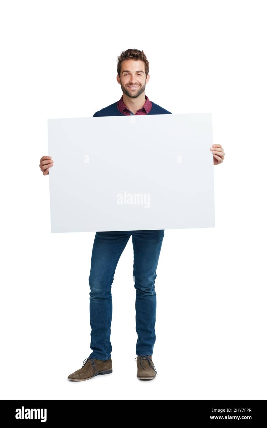 Copyspace für Ihre individuelle Anpassung. Studioporträt eines hübschen Mannes, der ein leeres Plakat vor einem weißen Hintergrund hält. Stockfoto