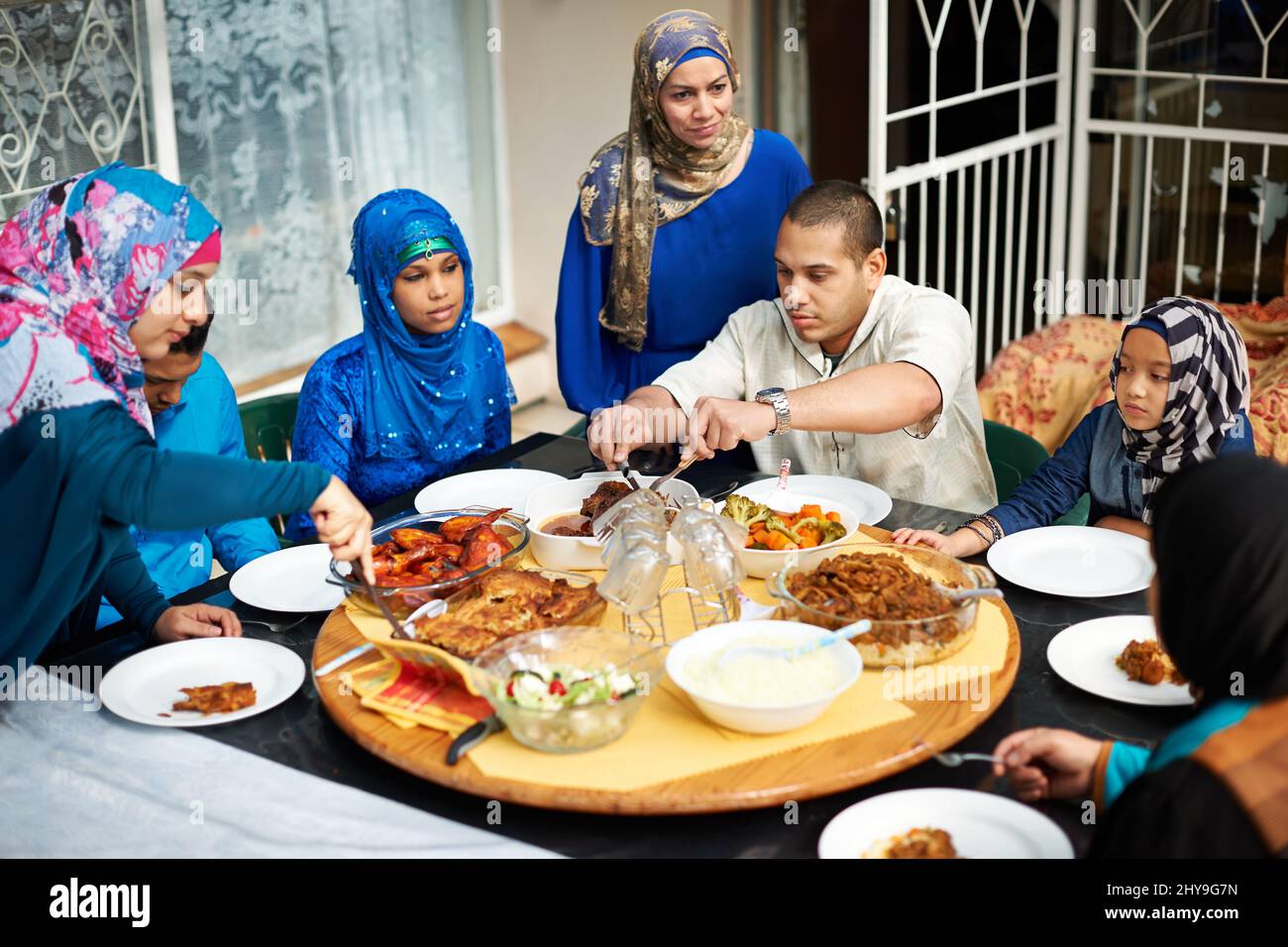Dig in jeder. Aufnahme einer muslimischen Familie, die zusammen isst. Stockfoto