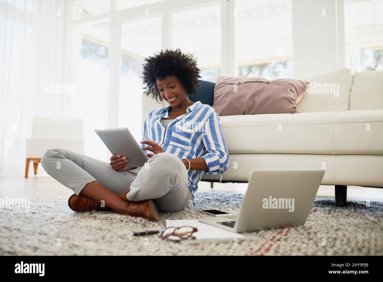 Ihr Blog hat sie zu einer Online-Sensation gemacht. Aufnahme einer jungen Frau, die zu Hause an ihrem digitalen Tablet und Laptop arbeitet. Stockfoto