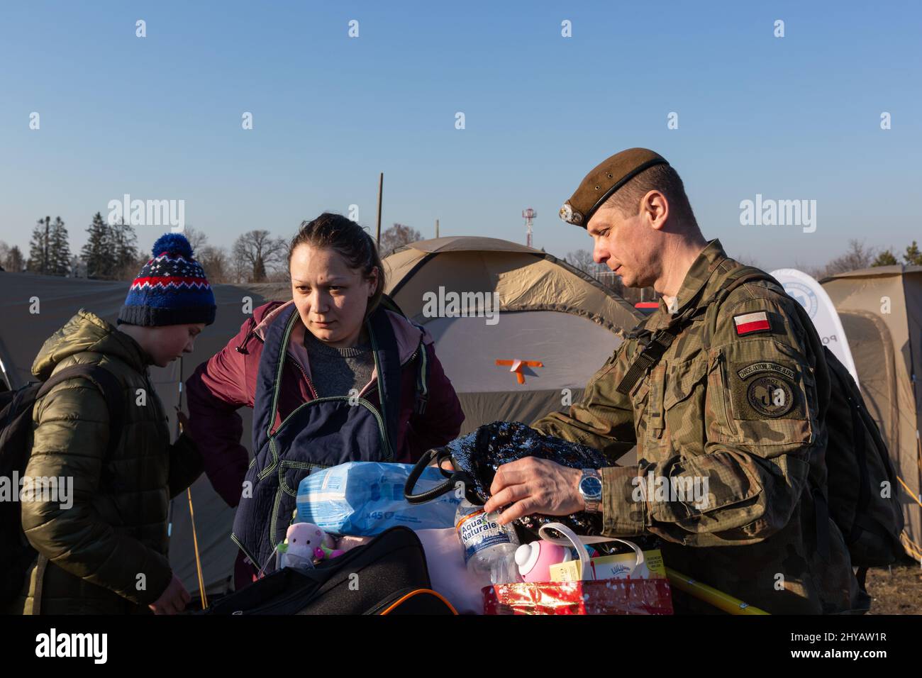 Medkya, Ukraine. 14. März 2022. Am 14. März 2022 hilft ein polnischer Soldat ukrainischen Flüchtlingen, ihre Sachen aus der Ukraine nach Medyka, Polen, zu tragen. Russische Streitkräfte sind Anfang des Monats in die Ukraine eingedrungen. (Foto: Daniel Brown/Sipa USA) Quelle: SIPA USA/Alamy Live News Stockfoto