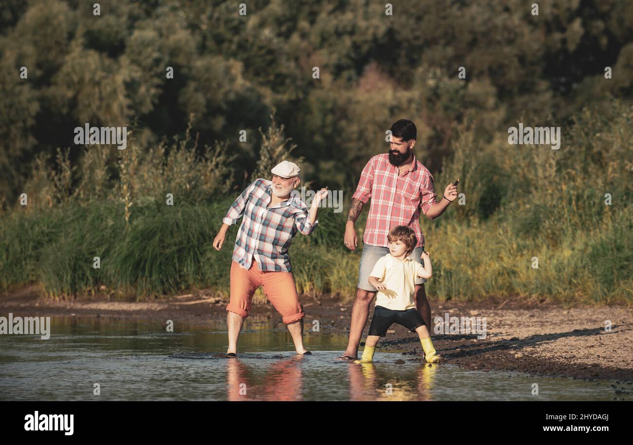 Familienspiel des Steinspringens. Familie in drei Generationen. Vater, Sohn und Großvater entspannen sich zusammen. Stockfoto