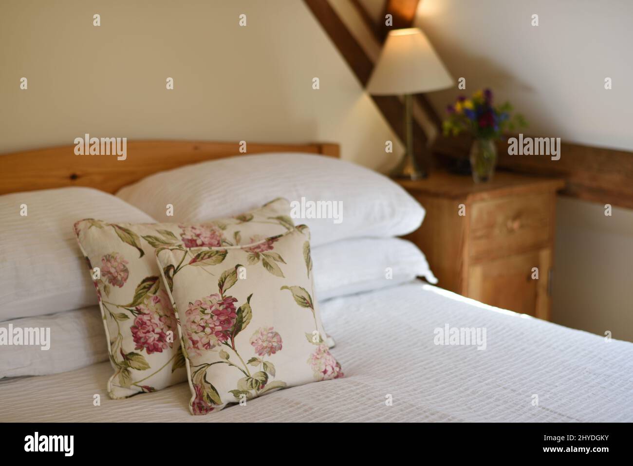 Inneneinrichtung eines Zimmers im Landhausstil und eines Bettes mit Kissen Stockfoto