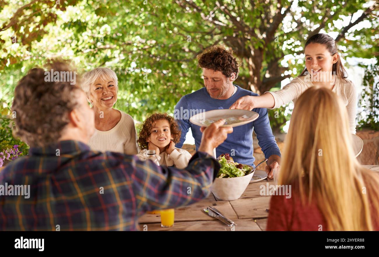 Ich will Euch, Opa, nicht servieren. Ein Blick auf eine Familie, die sich darauf vorbereitet, gemeinsam im Freien zu essen. Stockfoto