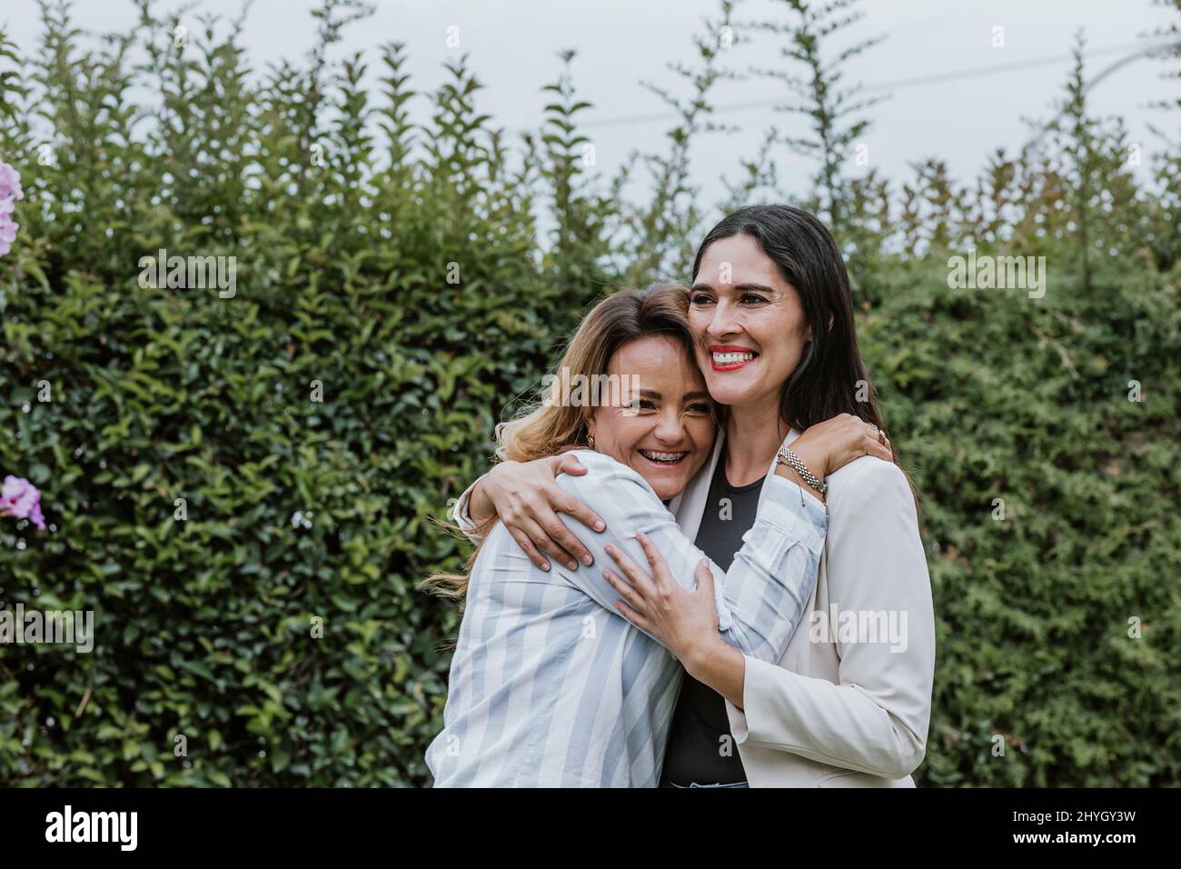 Zwei lateinamerikanische Freundinnen umarmen sich im Terrassenbüro in Mexiko, Lateinamerika Stockfoto