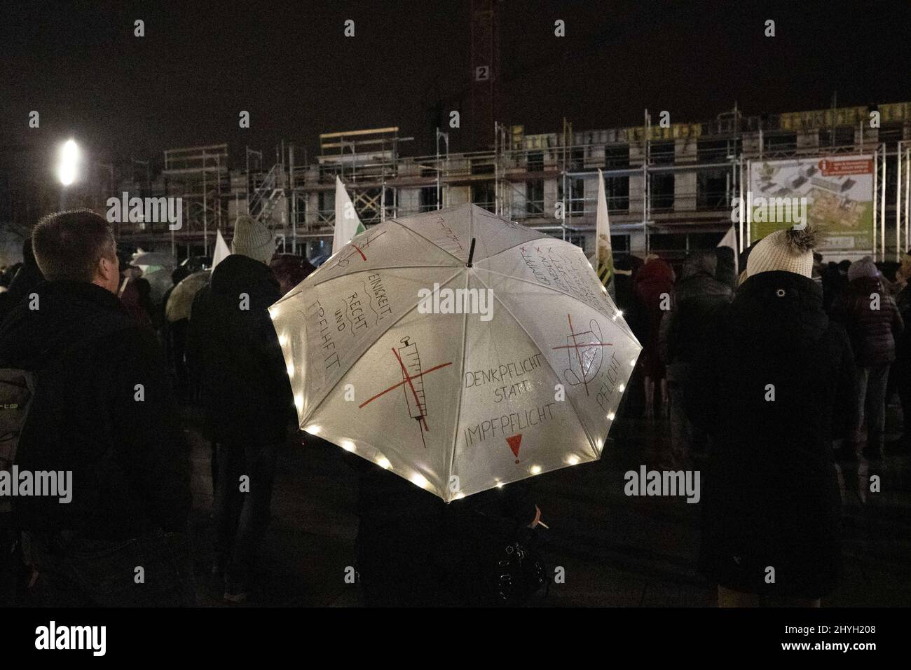 Heidenau, Deutschland. 14. März 2022. Eine Frau hält einen Regenschirm mit Slogans gegen die Zwangsimpfung während einer Rede von Landratsamtkandiat Hofmann (aka DJ Happy Vibes), der im Namen der Freisächsischen Partei für den Posten von Landrat im Landkreis Sächsische Schweiz-Osterzgebirge kandidigt. Die Freisächsische Partei wird derzeit vom Amt für Verfassungsschutz im Freistaat Sachsen überwacht. Quelle: Daniel Schäfer/dpa-Zentralbild/dpa/Alamy Live News Stockfoto