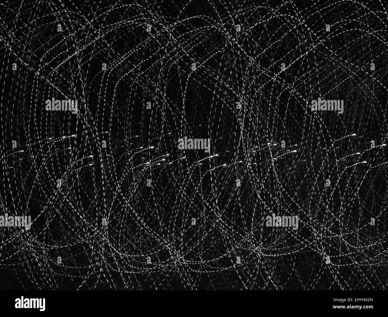 Abstrakte weiße Linien auf schwarzem Hintergrund. Verrückter Wirbel von vielen weißen Linien. Lichtmalerei Fotografie Stockfoto