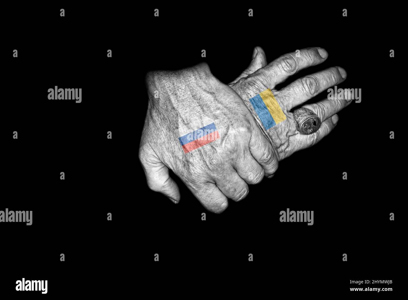 Zwei gekreuzte Hände mit der russischen und der ukrainischen Flagge als Tätowierung auf dem Handrücken Stockfoto