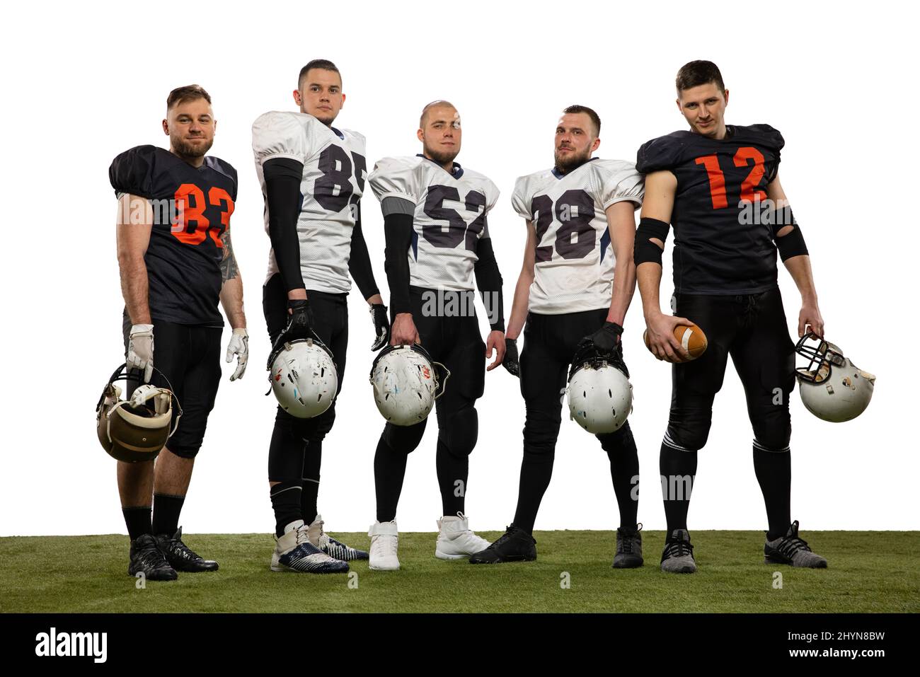 Gruppe junger sportlicher Männer, professioneller amerikanischer Fußballspieler in Sportuniform und Ausrüstung, die isoliert auf weißem Hintergrund posiert. Stockfoto