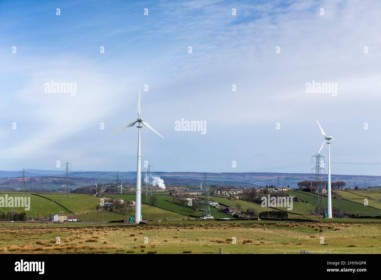 Windmühlen auf einem Windpark in der Nähe von Thornton, Bradford, West Yorkshire, an einem Frühlingstag mit blauem Sonnenschein in den Pennines. Sie liegen auf Ackerland und grenzt an Moorland, landwirtschaftliche Gebäude, örtliche Bauernläden und kleine Unternehmen. Kredit: Windmill Images/Alamy Live Nachrichten Stockfoto