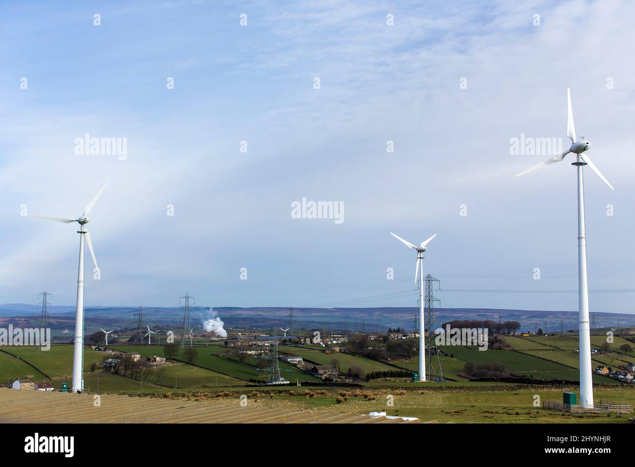 Windmühlen auf einem Windpark in der Nähe von Thornton, Bradford, West Yorkshire, an einem Frühlingstag mit blauem Sonnenschein in den Pennines. Sie liegen auf Ackerland und grenzt an Moorland, landwirtschaftliche Gebäude, örtliche Bauernläden und kleine Unternehmen. Kredit: Windmill Images/Alamy Live Nachrichten Stockfoto