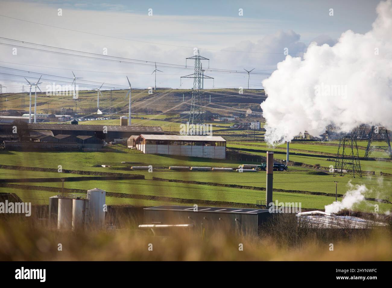 Dampfpumpen aus dem Kamin der Robinson- und Mitchells-Fabrik in der Nähe von Thornton, Bradford, England, West Yorkshire, Großbritannien. Dampf ist Wasser in der Gasphase. Dies kann durch Verdunstung oder durch Sieden auftreten, bei dem Wärme aufgebracht wird, bis das Wasser die Enthalpie der Verdampfung erreicht. Gesättigter oder überhitzter Dampf ist unsichtbar; „Team“ bezieht sich jedoch häufig auf nassen Dampf, den sichtbaren Nebel oder Aerosol von Wassertropfen, die sich aus der Kondenierung von Wasserdampf bilden. Kredit: Windmill Images/Alamy Live Nachrichten Stockfoto