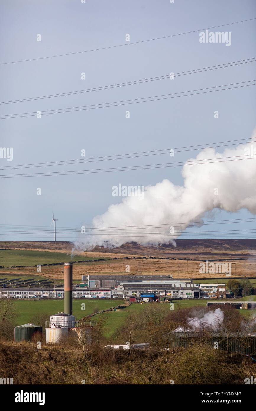 Dampfpumpen aus dem Kamin der Robinson- und Mitchells-Fabrik in der Nähe von Thornton, Bradford, England, West Yorkshire, Großbritannien. Dampf ist Wasser in der Gasphase. Dies kann durch Verdunstung oder durch Sieden auftreten, bei dem Wärme aufgebracht wird, bis das Wasser die Enthalpie der Verdampfung erreicht. Gesättigter oder überhitzter Dampf ist unsichtbar; „Team“ bezieht sich jedoch häufig auf nassen Dampf, den sichtbaren Nebel oder Aerosol von Wassertropfen, die sich aus der Kondenierung von Wasserdampf bilden. Kredit: Windmill Images/Alamy Live Nachrichten Stockfoto