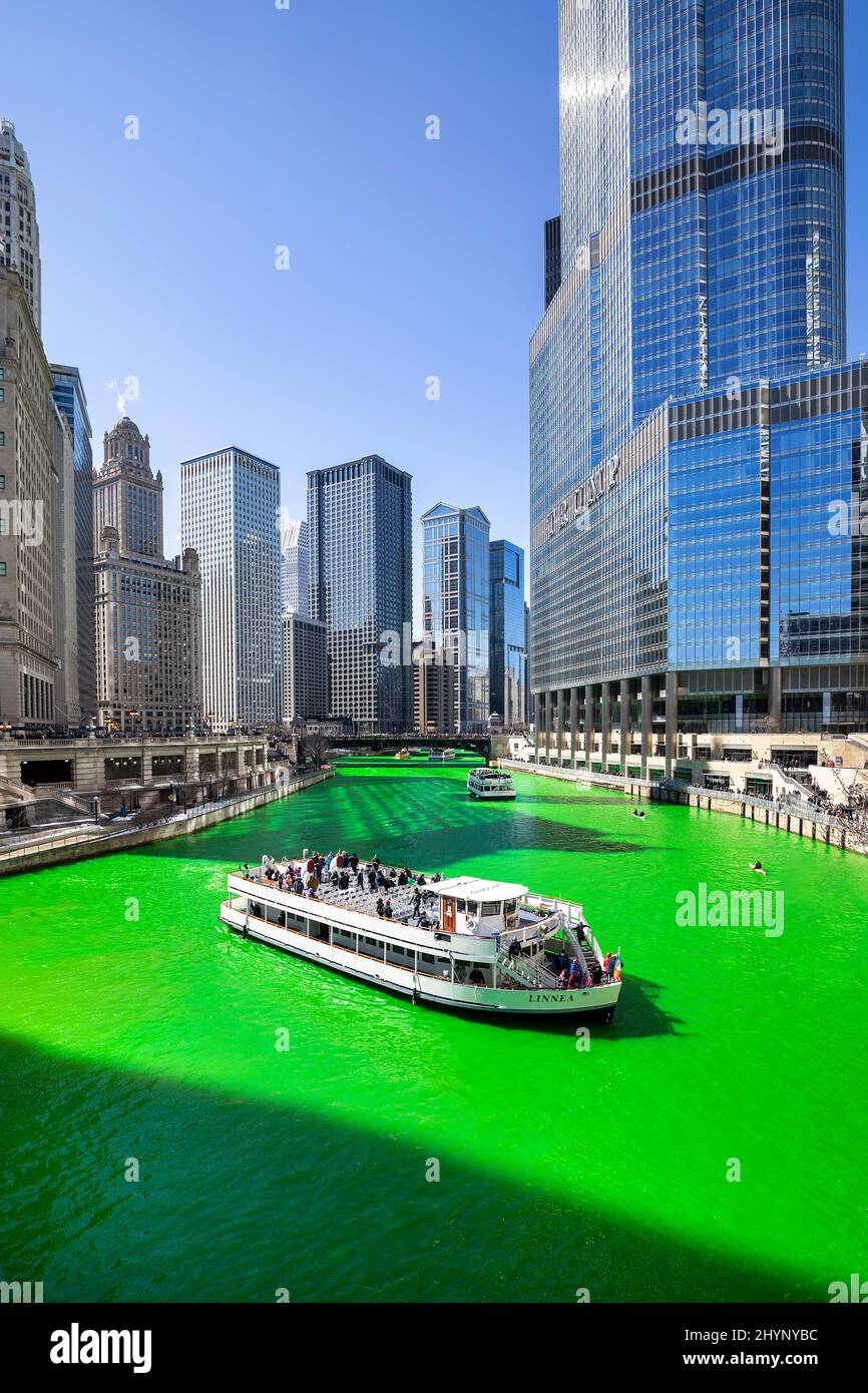 Verschiedene Boote fahren entlang des Chicago River, der zur Feier des St. Patrick's Day in der Innenstadt von Chicago grün gefärbt wurde. Stockfoto