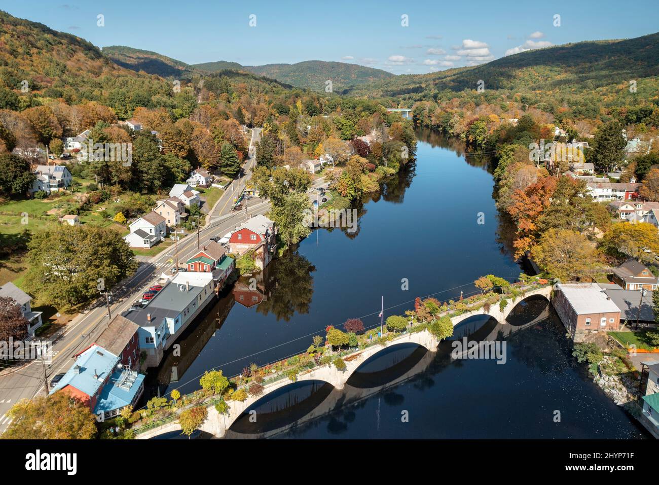 Die Bridge of Flowers überspannt den Deerfield River mit den sanften Hügeln des westlichen Massachusetts als Kulisse in Shelburne, MA im Herbst. Stockfoto