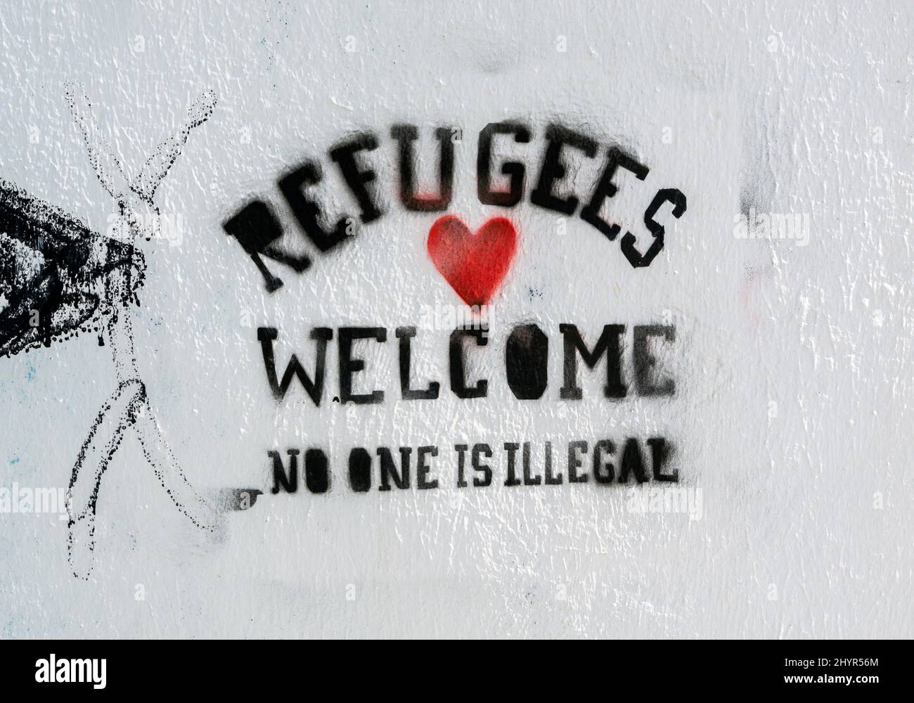 Schablonen-Graffiti auf weißem Hintergrund, die besagen, dass Flüchtlinge niemanden willkommen heißen, ist illegal Stockfoto