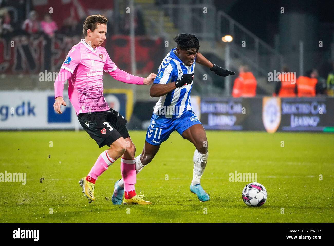 Odense, Dänemark. 14. März 2022. Emmanuel Sabbi (11) von ob und Jakob Ahlmann (3) von AAB beim Superliga-Spiel 3F zwischen Odense Boldklub und Aalborg Boldklub im Nature Energy Park in Odense. (Foto: Gonzales Photo/Alamy Live News Stockfoto