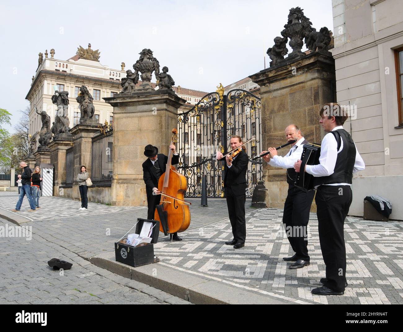 Vor der Prager Burg treten Musiker auf. Die Prager Burg ist eine Burg in Prag, wo die tschechischen Könige, die Heiligen Römischen Kaiser und die Präsidenten der Tschechoslowakei und der Tschechischen Republik ihre Büros hatten. Hier werden die Kronjuwelen des böhmischen Königreichs aufbewahrt. Die Prager Burg ist eine der größten Burgen der Welt. Stockfoto