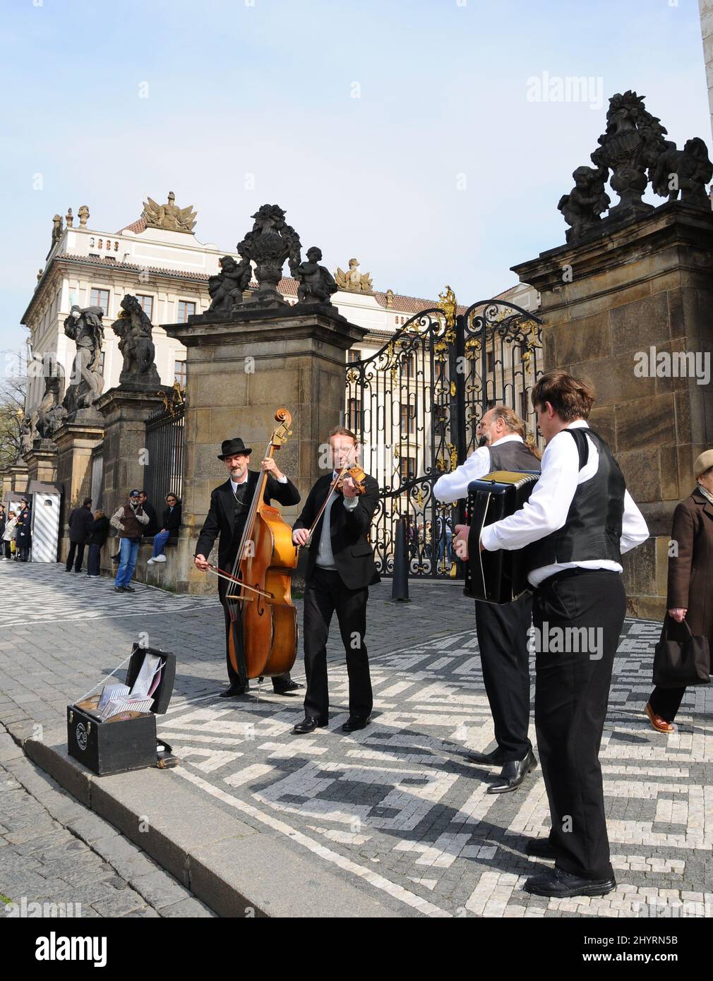 Vor der Prager Burg treten Musiker auf. Die Prager Burg ist eine Burg in Prag, wo die tschechischen Könige, die Heiligen Römischen Kaiser und die Präsidenten der Tschechoslowakei und der Tschechischen Republik ihre Büros hatten. Hier werden die Kronjuwelen des böhmischen Königreichs aufbewahrt. Die Prager Burg ist eine der größten Burgen der Welt. Stockfoto