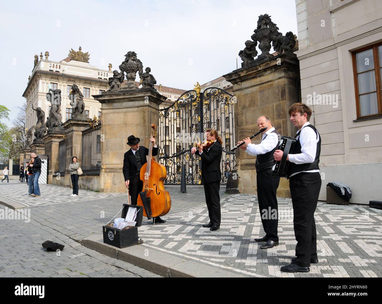 Vor der Prager Burg treten Musiker auf. Die Prager Burg ist eine Burg in Prag, wo die tschechischen Könige, die Heiligen Römischen Kaiser und die Präsidenten der Tschechoslowakei und der Tschechischen Republik ihre Büros hatten. Hier werden die Kronjuwelen des böhmischen Königreichs aufbewahrt. Die Prager Burg ist eine der größten Burgen der Welt. Stockfoto