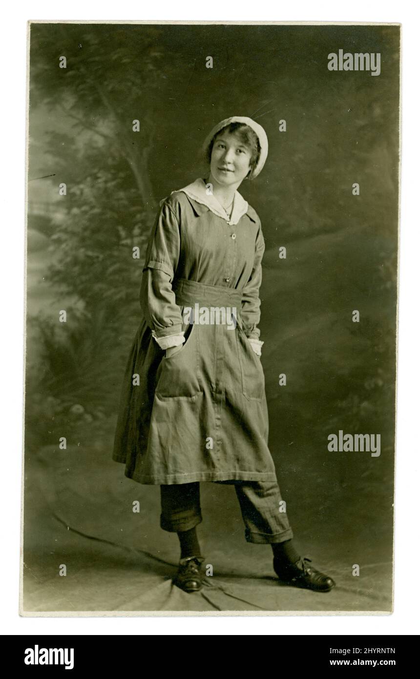 205-VBW1430 WW1 Postkarte aus der Ära der Munitionsarbeiterin, die stolz ihre Uniform zeigt, darunter Hosen, möglicherweise Yorkshire, Großbritannien, um 1917 Stockfoto
