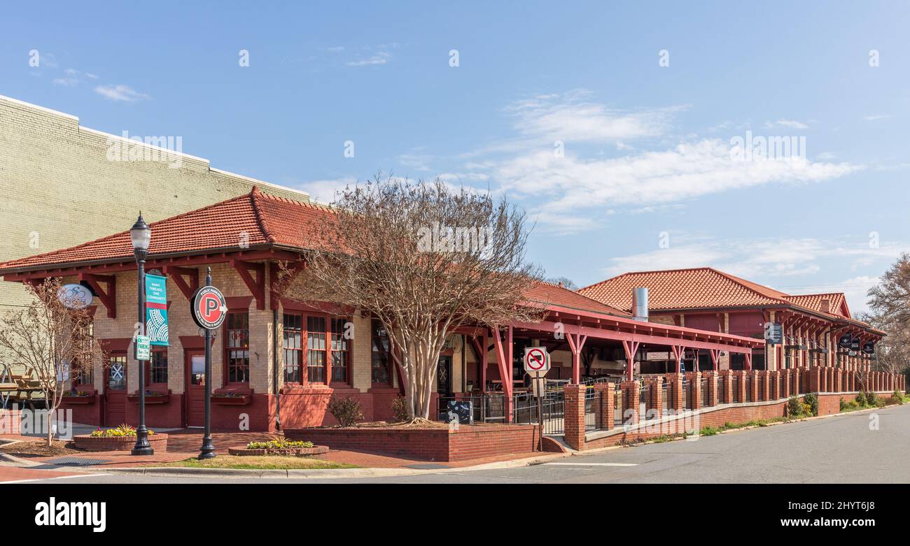 BELMONT, NC, USA-8 MARCH 2022: Altes Bahndepot, genannt North Main Station, umgewandelt in Geschäfte und Restaurant. Stockfoto