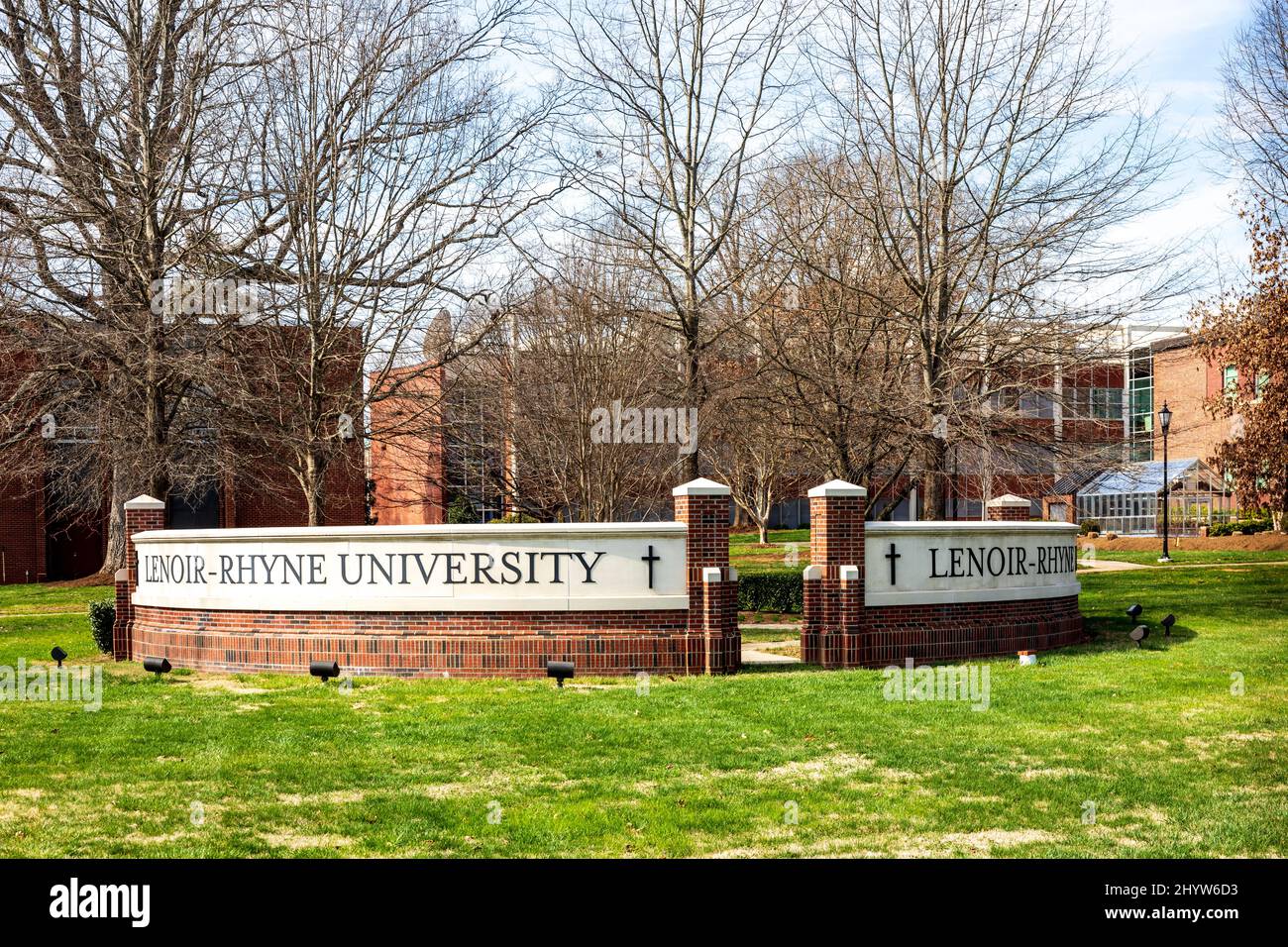 HICKORY, NC, USA-8. MÄRZ 2022: Denkmal-Schild der Lenoir-Rhyne University mit Campus dahinter. Stockfoto